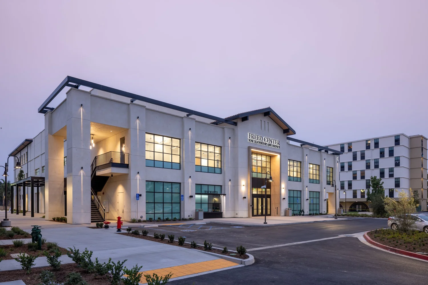 The Freed Center at Vanguard University at dawn, with lit windows and a landscaped entry